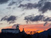Rechts vom Schloß Hohenaschau leuchtet eine rötliche Wolkenschicht